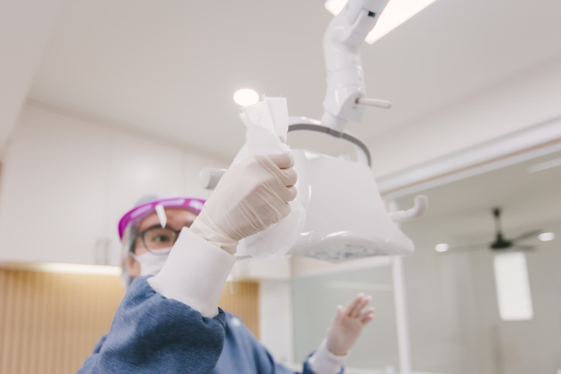 Dentist adjusting dental light before procedure